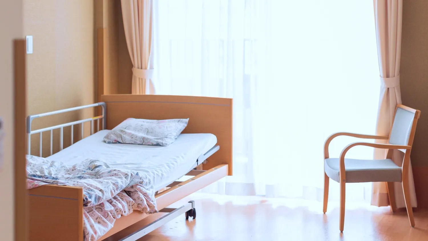 老人ホームの部屋に置かれたベッドと椅子